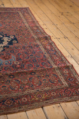 Ornate Bijar rug corner, showcasing rose and Herati motifs in madder red and navy.