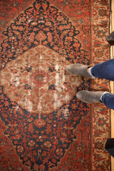 Antique Malayer rug detail: brick red and navy floral roundel medallion, showing exposed foundation.