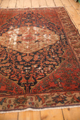 Antique Malayer rug: worn roundel medallion, floral field, exposed foundation, brick red, navy.