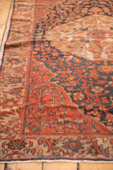 Antique Malayer rug's brick red field with navy floral cross sections and visible foundation wear.
