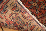 Antique Malayer rug's worn brick red pile and finely hand-knotted beige foundation.