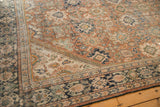 Distressed vintage Mahal carpet corner, showing worn terracotta field, palmette motifs, and navy border.