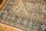 Mahal rug corner, navy blue border, muted orange palmettes, and textured, mostly even wear.