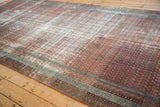 Distressed texture of an antique Malayer runner showing its worn terracotta pile and blue border accents.