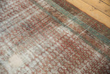 Angled view of a distressed Malayer rug's texture, showing wear to the exposed cotton foundation.