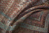 Soft folds on a distressed Malayer runner reveal character-rich texture and terracotta boteh motifs.