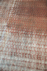 Worn terracotta boteh motifs over the restrung foundation of a distressed Malayer rug.