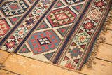 Antique Shirvan Kilim border featuring woven fire design motifs, geometric patterns, and fringe.
