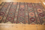 Detail of the antique Shirvan Kilim's geometric banded pattern with woven fire motifs in navy, red, and beige.