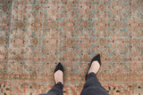 Distressed Persian Tabriz carpet showing faded sky blue and brick orange Herati pattern.