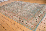 Detail of distressed Tabriz carpet corner, showcasing faded sky blue and terra cotta Herati design.