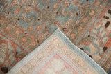 Folded distressed Tabriz carpet showing sky blue, terra cotta Herati pattern and foundation.