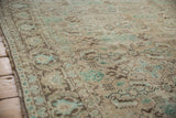 Worn Herati pattern detail on a distressed vintage Shiraz carpet in ivory and sea foam green.