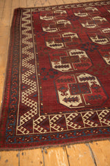 Cherry red Ersari carpet showing intricate hook and latch meandering border and gul motif.