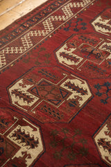 Textured Ersari rug detail: cherry red elephant footprint gul, ivory hook and latch border.
