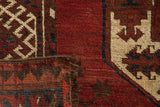 Vintage Ersari rug close-up: cherry red pile, ivory elephant gul, navy accents, dark fringe.