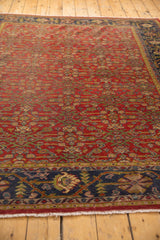 Vintage Mahal carpet corner showing navy border, splayed floral motif, and ivory fringe.