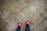 Red sneakers on a distressed Yazd carpet, highlighting faded floral bouquets and palmettes.