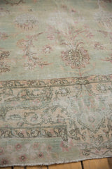 Distressed Yazd carpet corner, showing sea foam green field, blush palmettes, and worn pile.