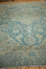 Softened sky blue and ivory scrolling vinery on distressed vintage Persian Tabriz.