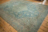 Distressed vintage Tabriz carpet showing worn blue and ivory field with floral vinery.