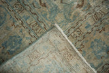 Folded vintage distressed Tabriz rug showing sky blue pile, vinery, and ivory foundation.