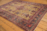 Corner of vintage Persian Sarouk rug, with gold field, navy border, cherry red paisley, inscription.
