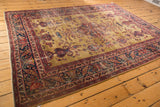 Vintage Sarouk carpet showcasing its gold field, central medallion, and germinating paisley design.