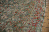Distressed Mahal rug's celadon green field, visible wear, and brick red floral border.