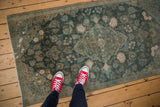 Distressed vintage Kashan rug with faded aqua teal, ivory, and powder blue floral patterns.