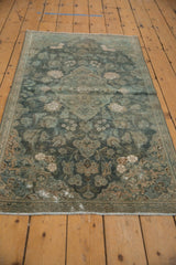 Distressed vintage Kashan rug featuring aqua floral field and faded ivory patterns.