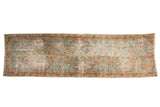 Faded distressed Kerman runner with light blue, ivory, and blush Persian motifs.