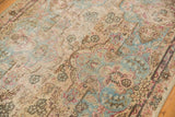 Visible wear and faded European-inspired motifs on a distressed Kerman runner.