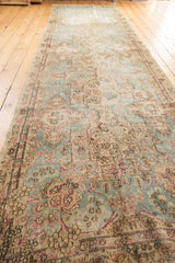 Distressed Kerman runner with faded sky blue, ivory, and cochineal red Rococo floral motifs.