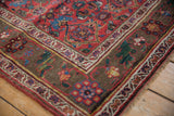 Antique Kurdish Bijar rug corner, dark oxidized bronze vine border and cherry red field.