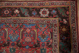 Antique Kurdish Bijar rug corner showcasing meandering vine border, cherry red field, and fringe.