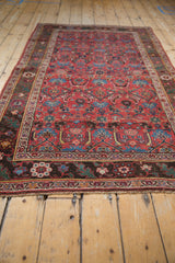 Antique Kurdish Bijar rug corner, cherry red field, oxidized bronze floral vine border.