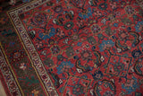Antique Kurdish Bijar rug, cherry red floral field, time-softened hues, and ivory vine border.