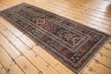 Antique Kerman runner with contrasting navy blue, cochineal, and bronze floral medallions.
