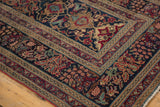 Antique Persian Kerman runner's intricate floral patterns in navy, red, and bronze borders.