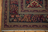 Intricate floral borders and white fringe of antique Persian Kerman rug.