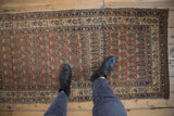 Antique Haji Jalili Tabriz runner field: terra cotta rust with staggered navy boteh design.