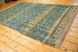 Distressed texture and blue, sand gul motifs on vintage Belouch carpet with purple plain weave.