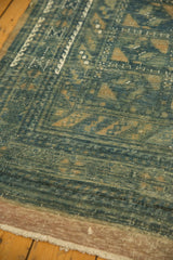 Distressed vintage Belouch carpet texture with faded blue gul motifs and sand tones.