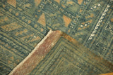 Vintage distressed Belouch carpet corner with faded blue pile, purple plain weave, and ivory fringe.