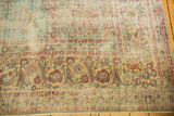 Distressed Kerman rug border showing sprawling vinery, floral motifs, and mostly even wear.