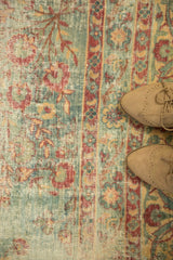 Distressed vintage Kerman carpet detail: powder blue field with cochineal red floral motifs.
