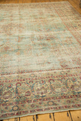Softened cochineal red and powder blue scrolling vinery on distressed Kerman rug border.