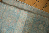 Rolled vintage distressed Mahal rug runner showing mostly even wear with blue-green and terracotta tones.