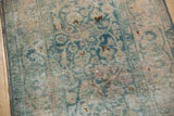 Distressed texture of vintage Meshed rug showing faded ocean green palmettes and foundation wear.